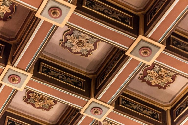 Techo artesonado con decoración ornamental dorada y rosetones del hotel Domus Zamittello