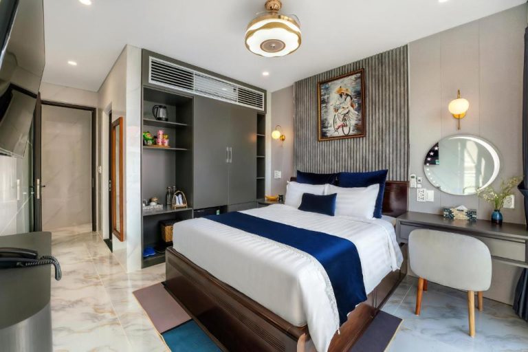 Habitación doble deluxe con cama king size y decoración elegante en Hannah House Hoi An