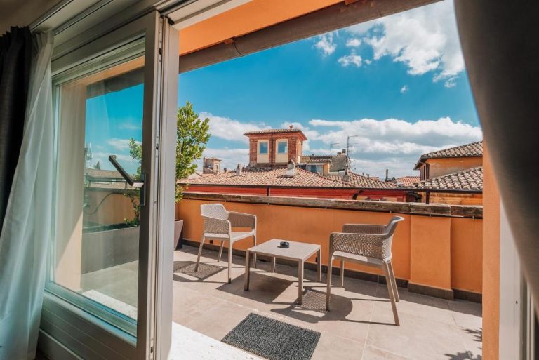 Terraza con sillas y mesa del Locanda della Posta Etruria Collection con vistas a los tejados