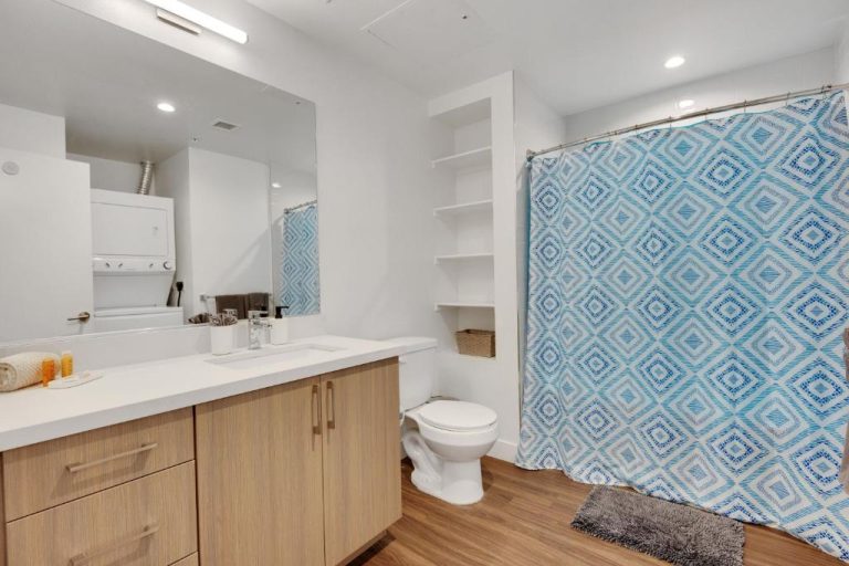 Baño completo con ducha, lavabo y lavadora del Apart Hotel at Chinatown en San Francisco