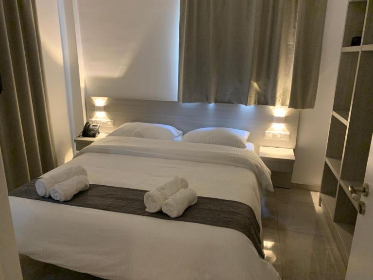 Habitación doble con cama matrimonial y toallas enrolladas en La Veranda Hotel