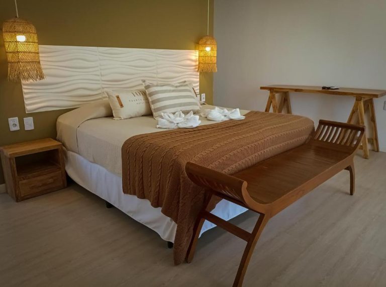Habitación doble con cama king y decoración en madera natural del Hotel Terrazas del Río Negro