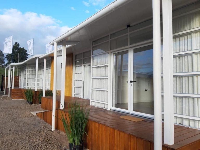 Fachada exterior con terraza de madera y ampios ventanales del Hotel Terrazas del Río Negro