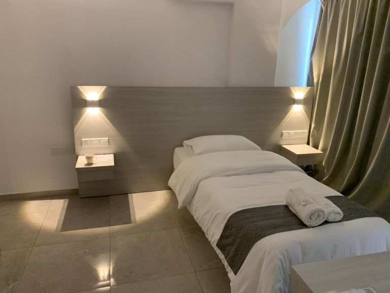 Habitación doble con dos camas individuales y cabecero iluminado en La Veranda Hotel
