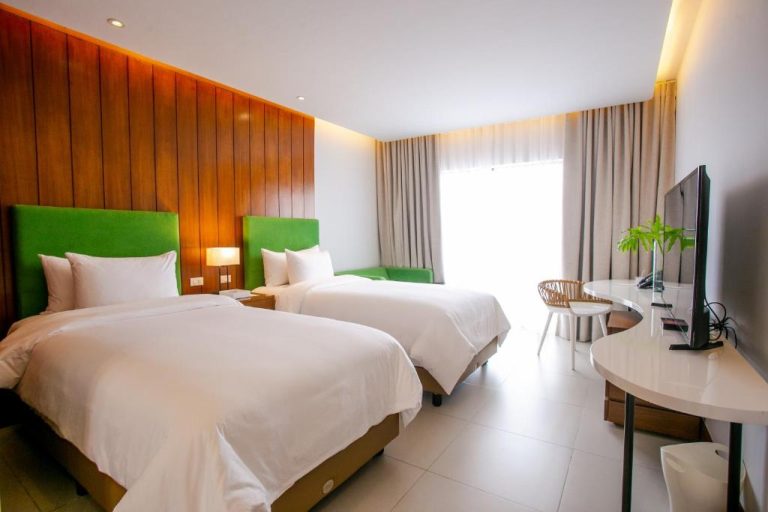 Habitación twin con cabeceros verdes y pared de madera en Timberland Highlands Resort