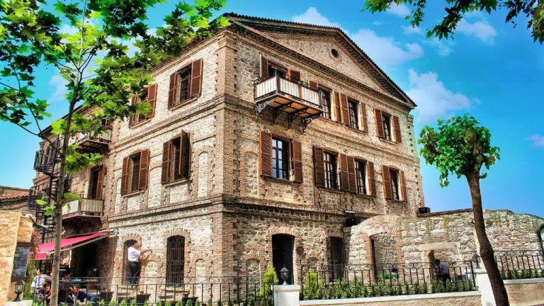 Fachada exterior de piedra del Giritligil Hotel, edificio histórico de tres plantas con ventanas de madera