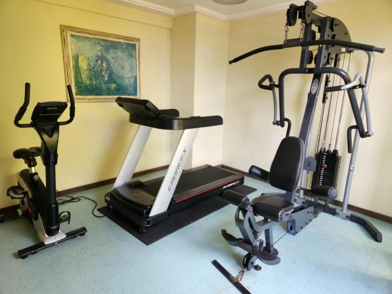 Gimnasio equipado con cinta de correr, bicicleta estática y máquina multifuerza en Hotel Casa do Amarelindo