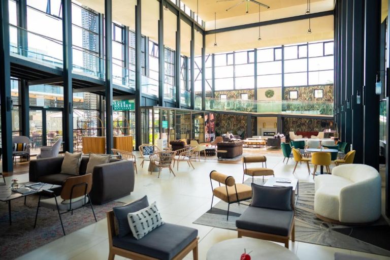 Amplio lobby lounge con sofás modernos y grandes ventanales en Royal Green Wellness Resort