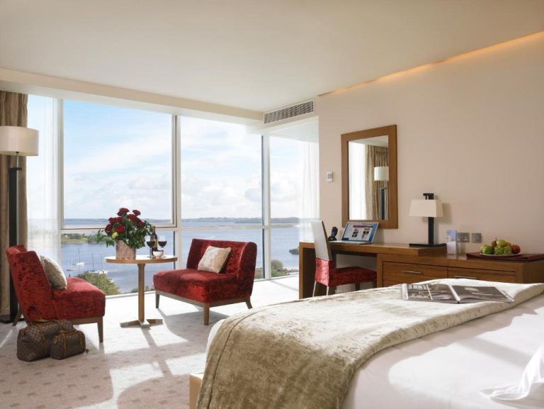 Habitación de lujo con vistas al lago y sillones rojos en el Hodson Bay Hotel Irlanda