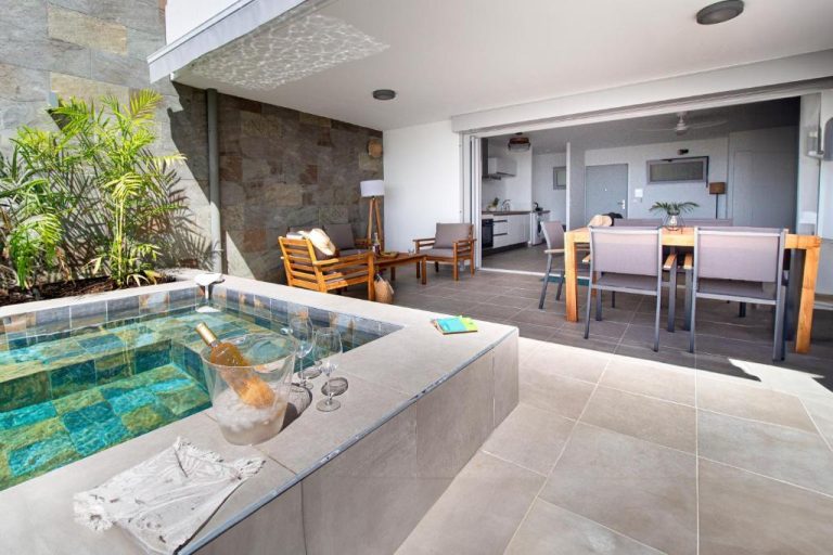 Jacuzzi privado con champán en terraza exterior de La Plage Martinique con salón y cocina integrados