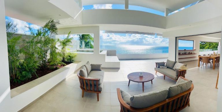 Terraza salón exterior con sofás y vista panorámica al mar en La Plage Martinique