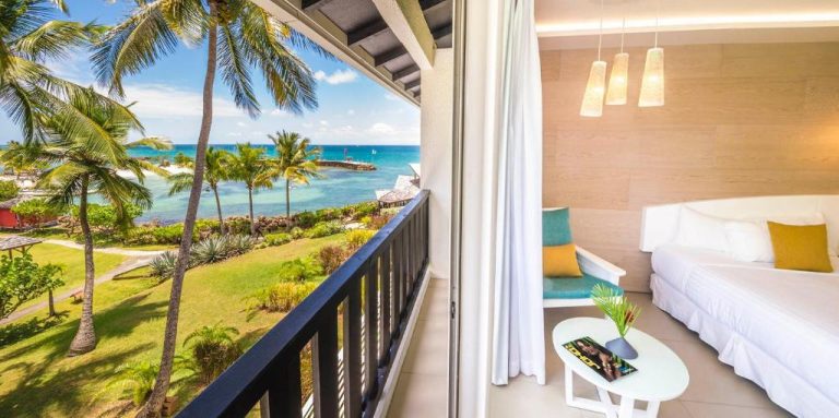Habitación con balcón y vista al mar turquesa en La Creole Beach Hotel & Spa Guadalupe