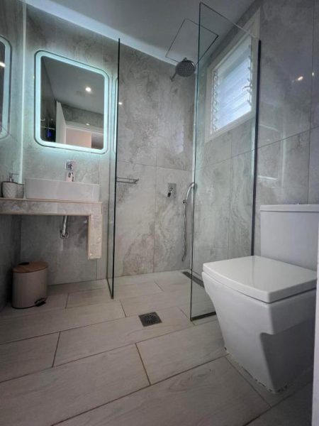 Baño moderno con ducha de lluvia y sanitarios blancos en Trenta Nove Studios