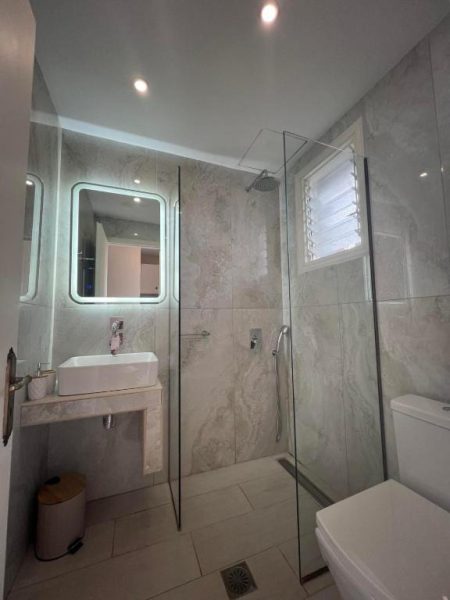 Baño moderno con ducha de lluvia y revestimiento de mármol en Trenta Nove Studios