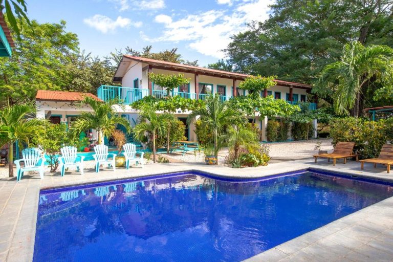 Piscina exterior con tumbonas y jardín tropical del Hotel Diversion Tropical en Costa Rica