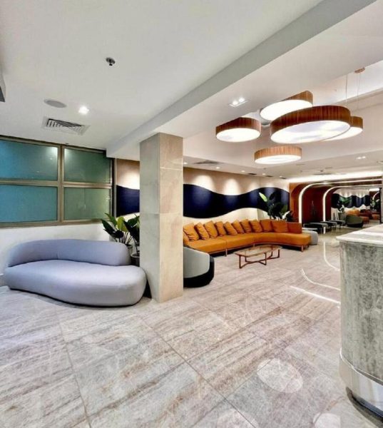 Amplio lobby del Hotel Astoria Palace con sofás modernos, iluminación elegante y decoración contemporánea en tonos neutros