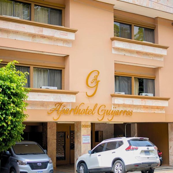 Fachada exterior del Aparthotel Guijarros con estacionamiento y entrada principal