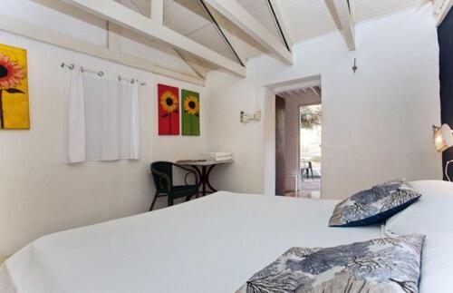 Habitación doble con cama blanca y decoración de girasoles en Landhuis Daniel Plantation House