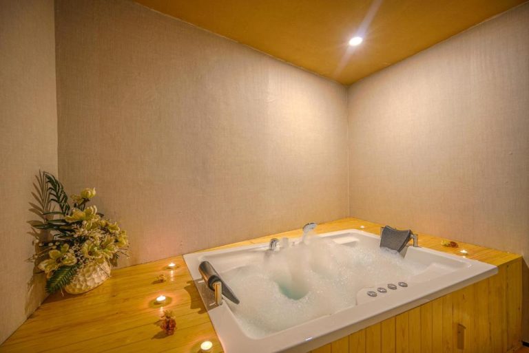 Jacuzzi con burbujas y velas románticas en el Lupo Libero Hotel Spa con decoración en madera