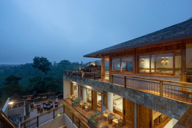 Terraza exterior con vistas al bosque del MăngDiang Boutique Hotel al atardecer con iluminación cálida