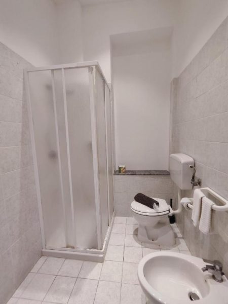 Baño completo con ducha, inodoro y bidé del Hotel Faraglione, decorado en tonos blancos