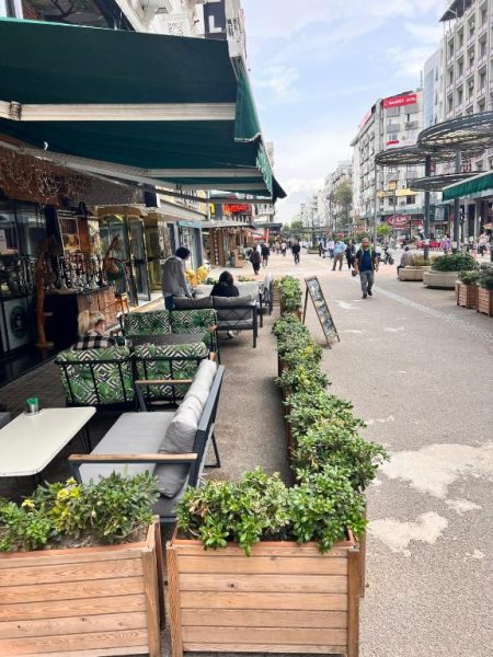 Terraza exterior con sofás y plantas del Mostar Hotel Antalya junto al paseo peatonal comercial