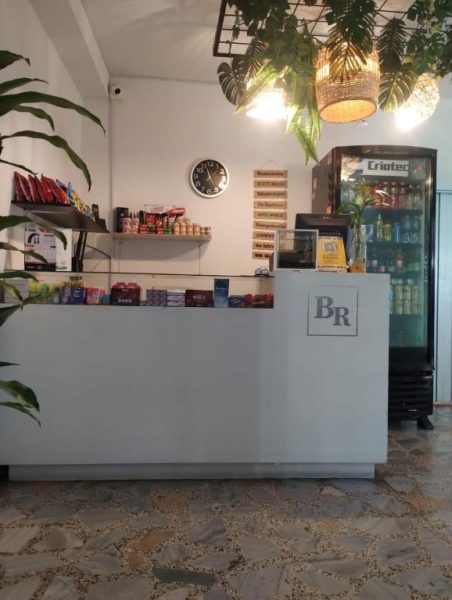 Recepción y tienda del Hotel Bayadera Real con nevera de bebidas y productos de snacks