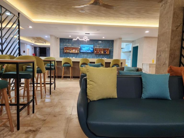 Bar lounge con sofás y taburetes del Hotel 39 Jamaica, zona de relax con barra y bebidas