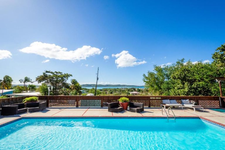 Piscina exterior con vistas al mar y terraza con tumbonas en West Coast Apartments