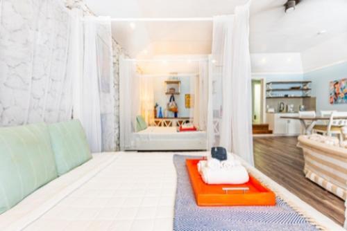 Habitación luminosa con cama de dosel y bandeja naranja en Studio Palms BC