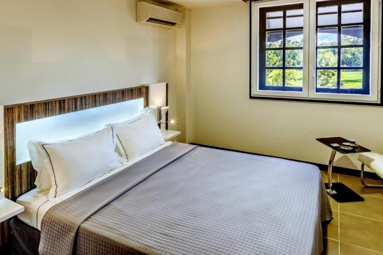 Habitación doble moderna con cama king y ventana con vistas al jardín en Residence Fort Savane