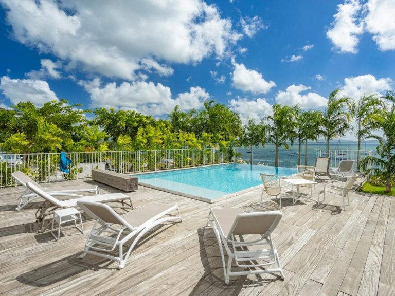 Piscina infinita con terraza de madera y vista al mar del B&B Hotel Fort-de-France en Martinica