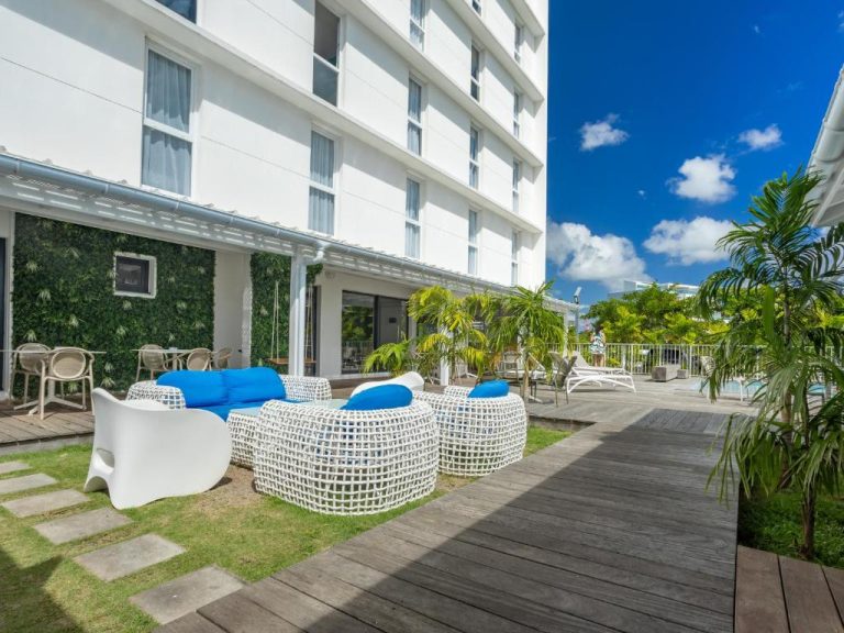 Terraza exterior con mobiliario moderno azul y blanco del B&B Hotel Fort-de-France junto a la piscina
