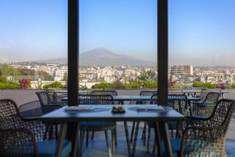 Terraza restaurante del Palace Catania UNA Esperienze con vistas al volcán Etna y la ciudad