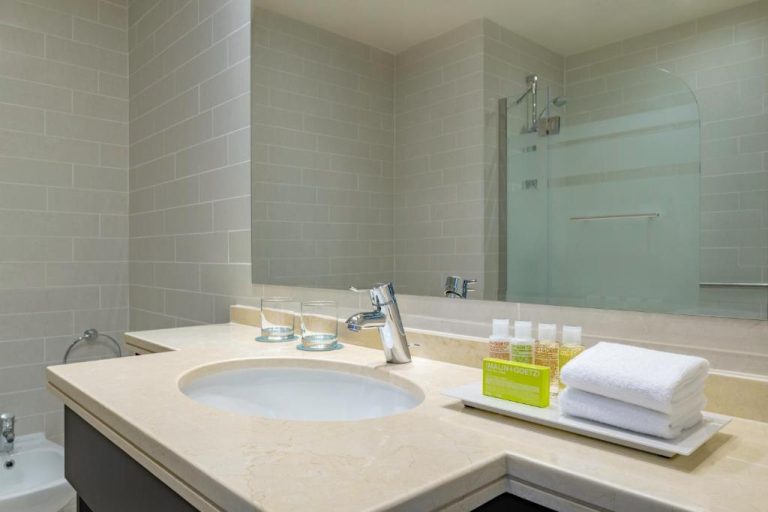 Baño de lujo con encimera de mármol y amenities Malin+Goetz en Le Meridien City Center Doha