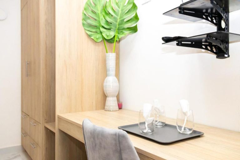 Escritorio de madera con sillas y copas de cristal en el Habana Hotel Y Restaurante