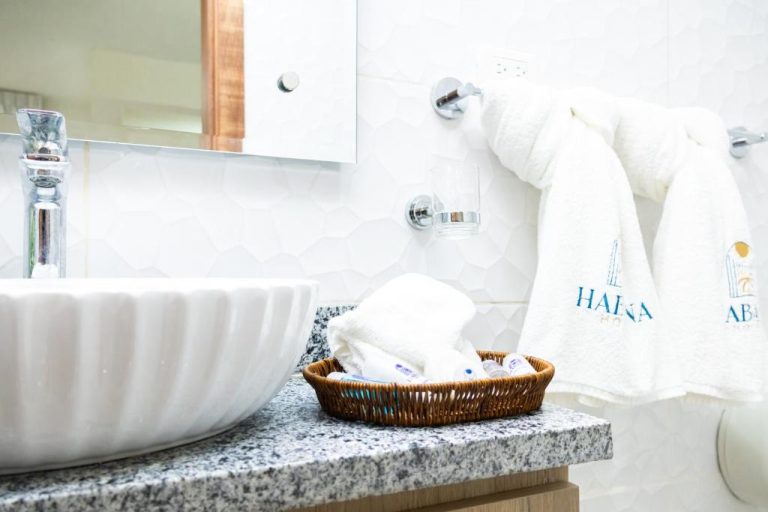 Baño moderno con amenities y toallas del Habana Hotel y Restaurante en Colombia