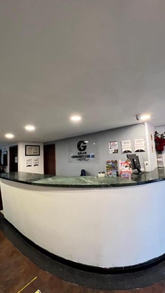 Recepción principal del Hotel Gran Conquistador 33 con mostrador de mármol y zona de atención al cliente