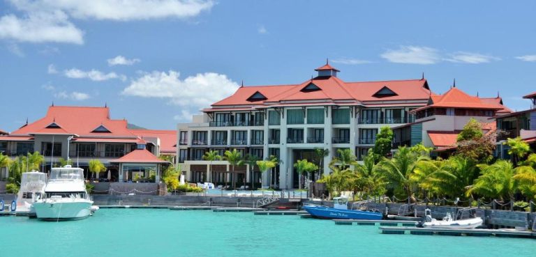 Vista exterior del Eden Bleu Hotel con marina de aguas turquesas y embarcaciones en Seychelles