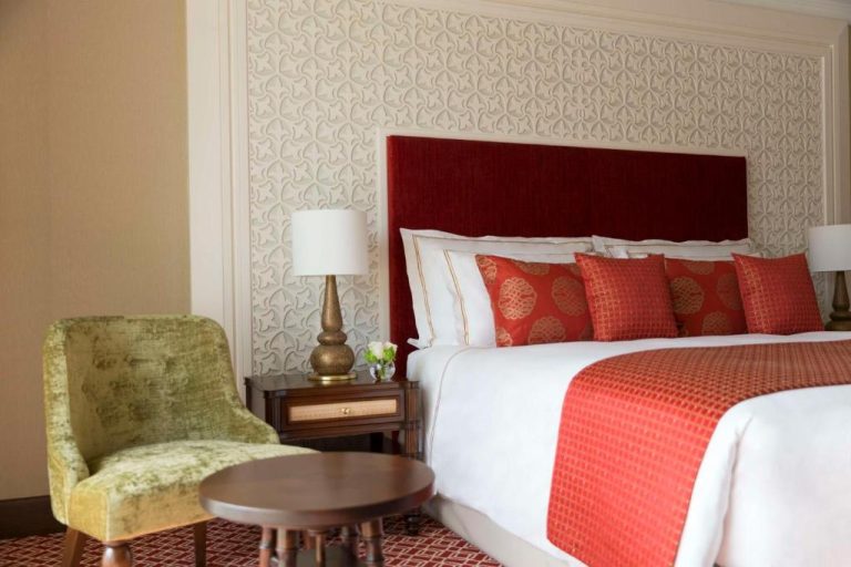 Habitación de lujo con cama king y cabecero rojo en Al Najada Doha Hotel by Tivoli
