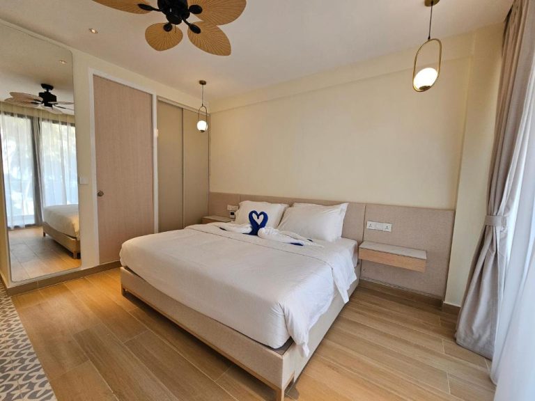 Habitación doble con cama matrimonial y decoración tropical en Kinan Boutique Hotel