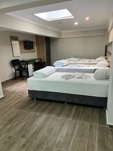 Habitación triple con tres camas individuales y suelo de madera en Marka Hotel