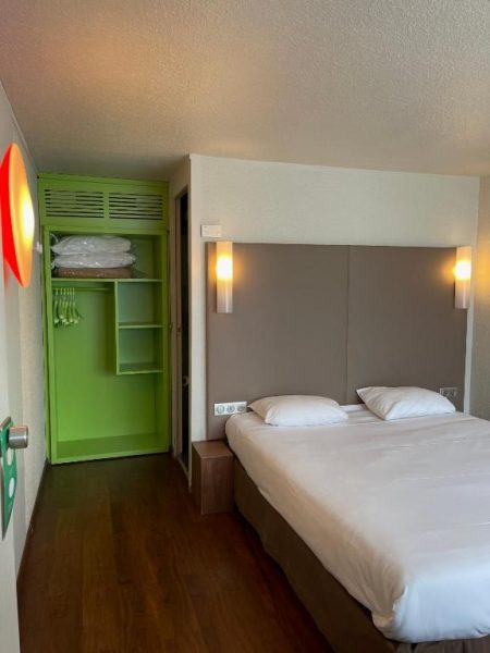 Habitación doble con cama matrimonial y armario verde en Hotel Campanile Montluçon Saint-Victor