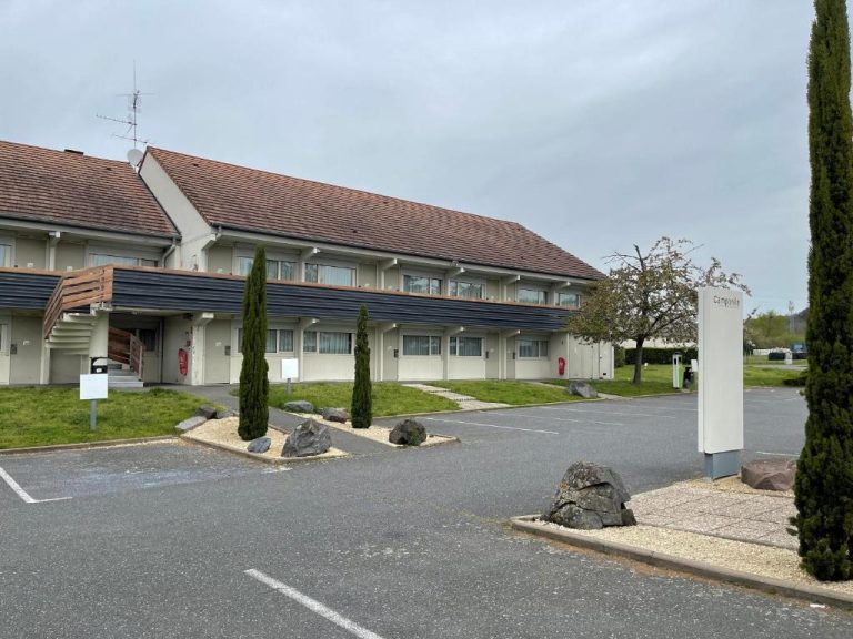 Fachada exterior y aparcamiento del Hotel Campanile Montluçon Saint-Victor con jardín y cipreses