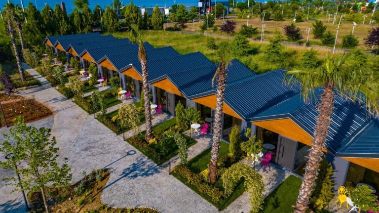 Vista aérea de los bungalows con jardín tropical y palmeras del Green Palace Suite Hotel