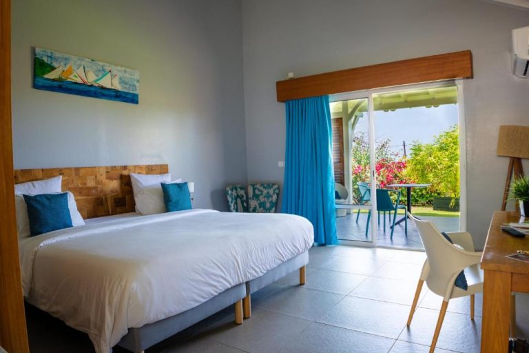 Habitación doble con terraza y jardín tropical en Hôtel Le Soleil Levant, decoración azul y madera