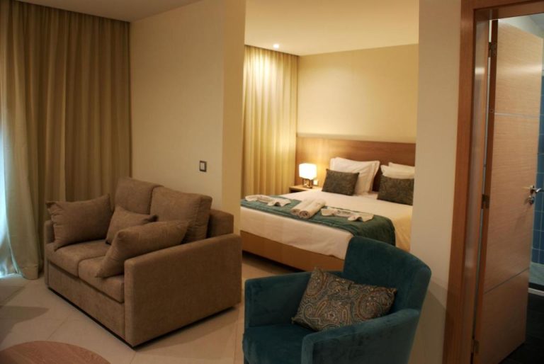 Suite del Beramar Hotel con salón, sillones y dormitorio con cama doble e iluminación cálida