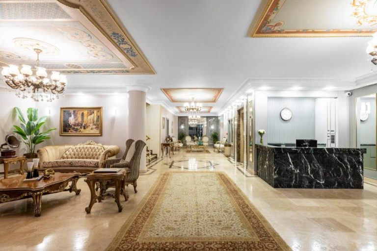 Elegante lobby con recepción de mármol negro y mobiliario clásico dorado en Rast Hotel Sultanahmet