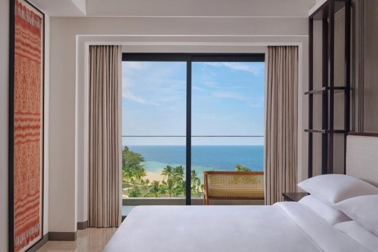 Habitación con cama doble y vista panorámica al mar y playa en Lampung Marriott Resort & Spa