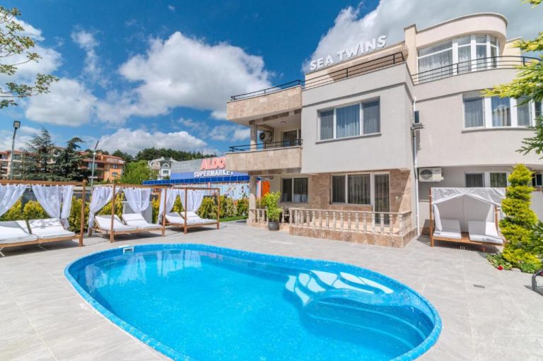 Piscina exterior con tumbonas y zona de relax del Sea Twins Luxury Aparthotel a 150 m de la playa